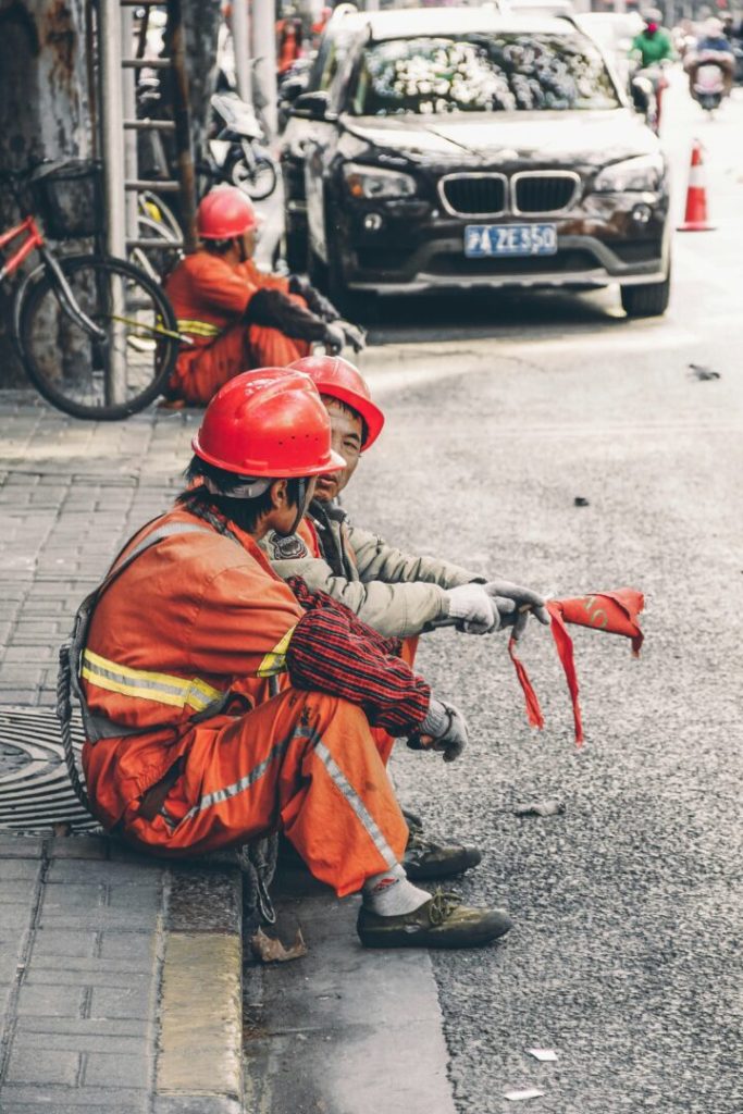 Operai in pausa al cantiere con casco e divisa arancione, simbolo di sicurezza sul lavoro