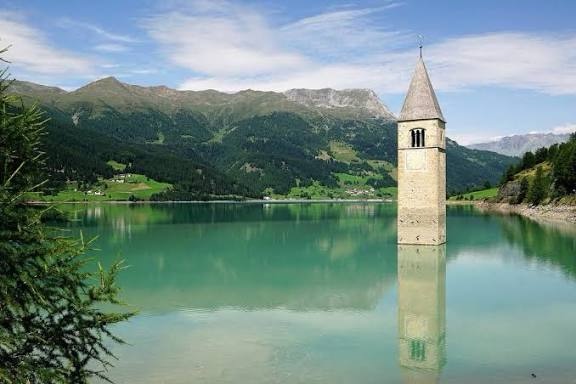Il mistero del Lago di Resia: la torre sommersa che ancora oggi affascina Campanile sommerso del Lago di Resia in Alto Adige, mistero e leggenda della torre che emerge dall’acqua