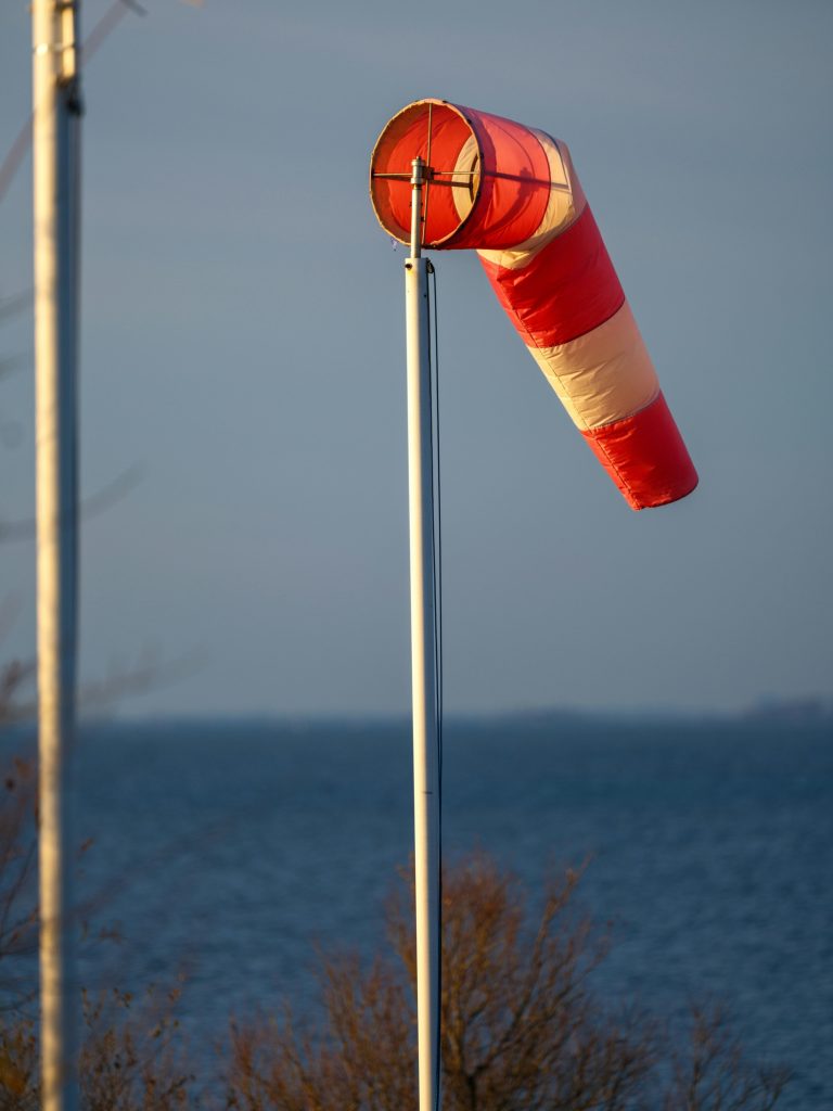 Meteo del Giorno previsioni dettagliate – 9 ottobre 2025 | Oiusho Manica a vento rossa e bianca che indica venti moderati sul mare in Italia il 9 ottobre 2025