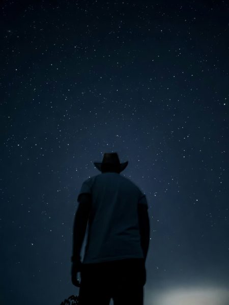 Uomo che osserva il cielo stellato nella notte, simbolo di misteri e oroscopo