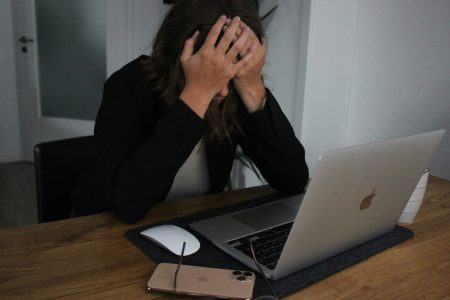 Come gestire lo stress quotidiano: tecniche efficaci che funzionano davvero – Oiusho Donna stressata davanti al computer – stanchezza mentale sul lavoro
