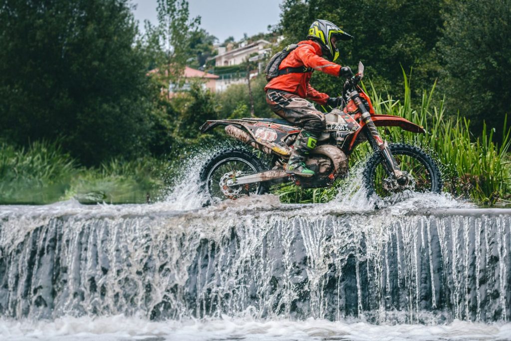 Motociclista sfida un fiume in piena: il gesto estremo finisce male motociclista attraversa un fiume in piena con la moto