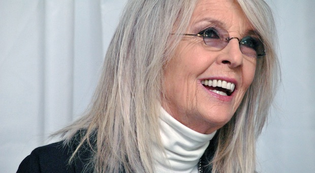 Diane Keaton è morta a 79 anni: addio alla leggenda de “Il Padrino” – Oiusho Diane Keaton ride indossando un dolcevita bianco e occhiali.