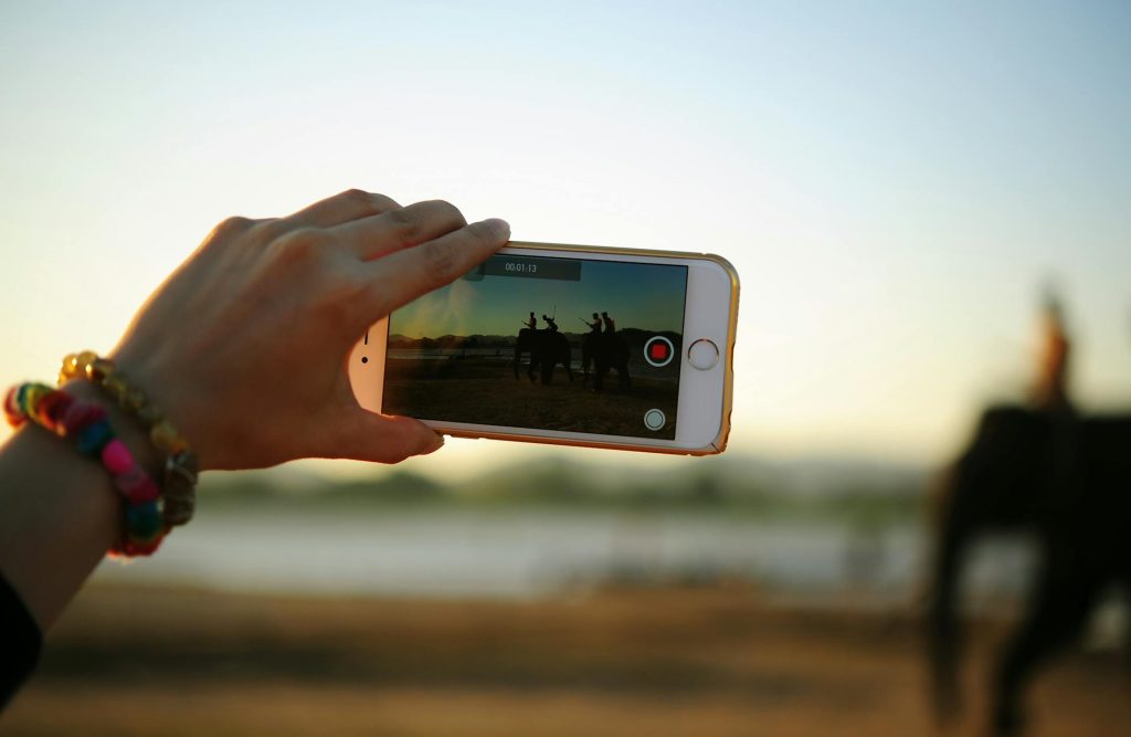 Persona che guarda e crea contenuti video su smartphone