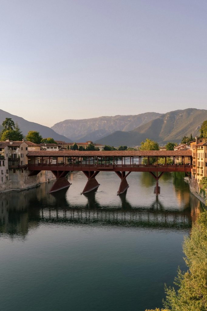 Bassano del Grappa, cosa vedere nella perla nascosta del Veneto: ponte, centro storico, natura e sapori unici Ponte degli Alpini a Bassano del Grappa sul fiume Brenta con panorama delle montagne venete