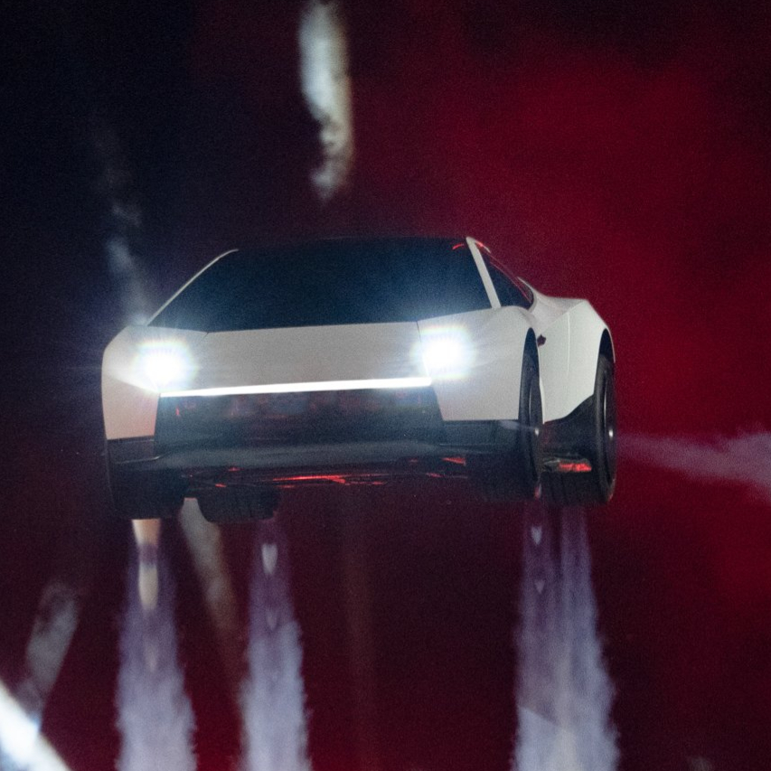 Tesla Roadster, Elon Musk presenta il prototipo che vola: acrobazie in aria e propulsori SpaceX Veicolo elettrico bianco sospeso in aria durante una dimostrazione con getti verticali